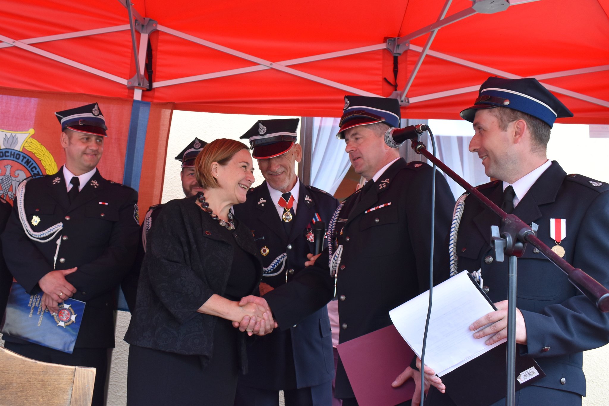 Członkini zarządu powiatu Teresa Jankowska gratuluje druhowi Jackowi Jonkiszowi, prezesowi OSP w Malcu.