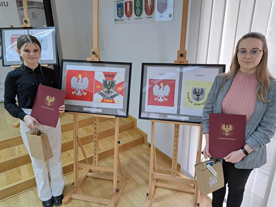 Na zdjęciu laureatki konkursu na sztandar powiatu na tle swoich prac