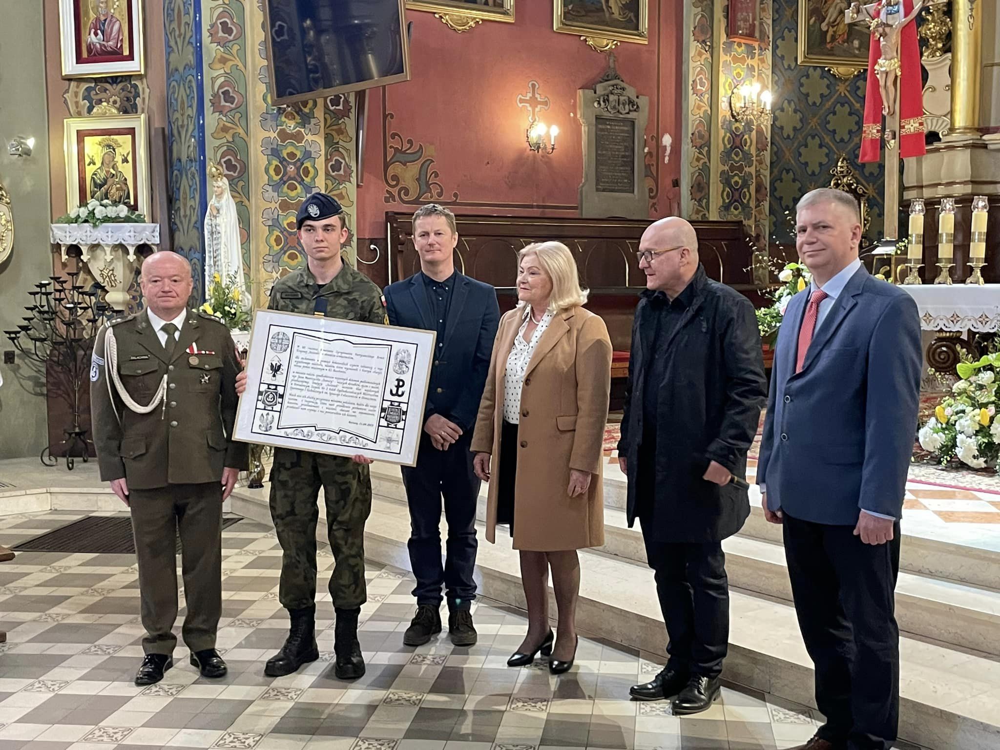 Na zdjęciu przedstawiciele stowarzyszenia Auschwitz Memento, rodzin siesienkowych, dyrektor powiatowego Chemika i jeden z uczniów klasy mundurowej.