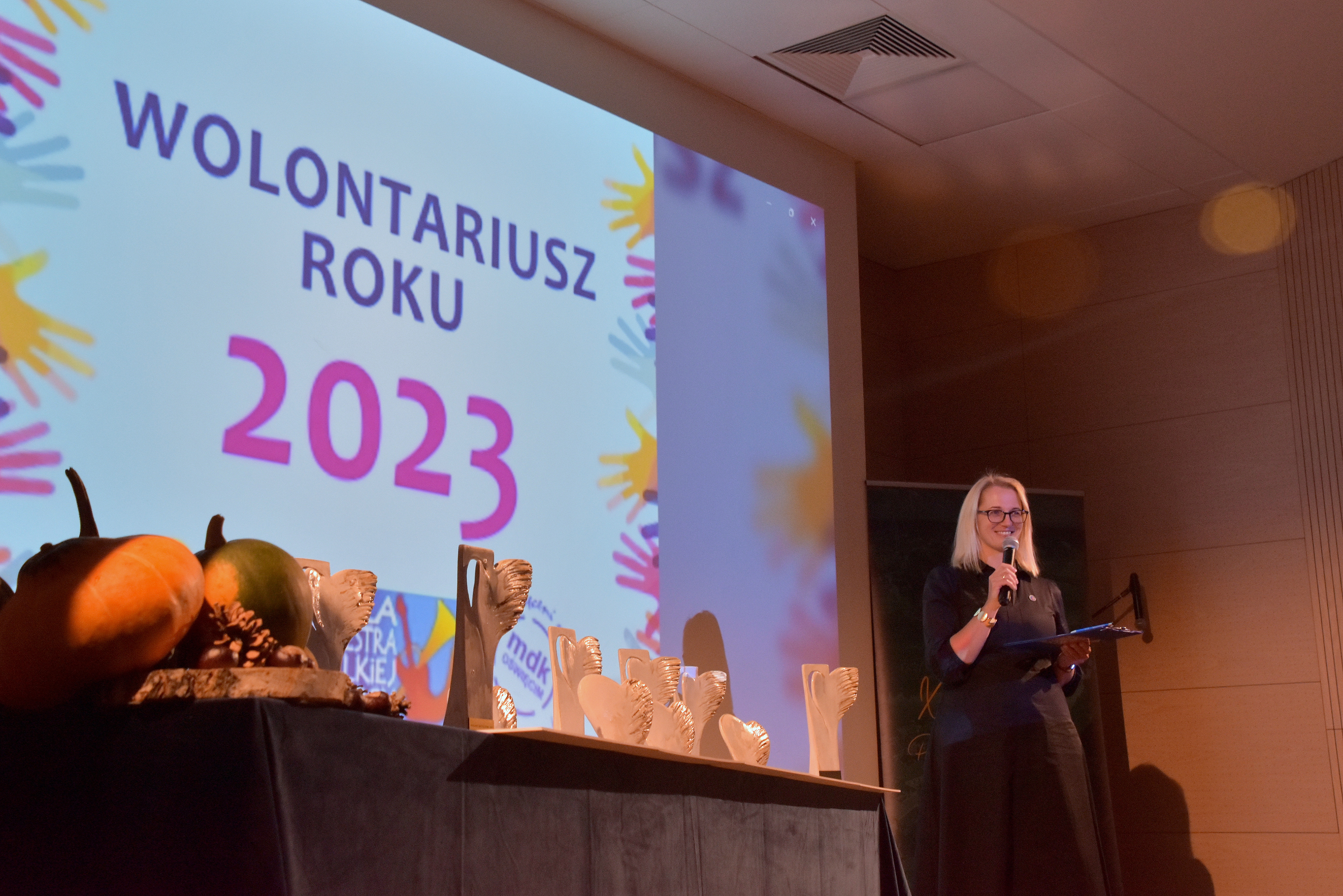 Widok na scenę i prowadzącą galę rozdania nagród w konkursie Wolontariusz Roku 2023