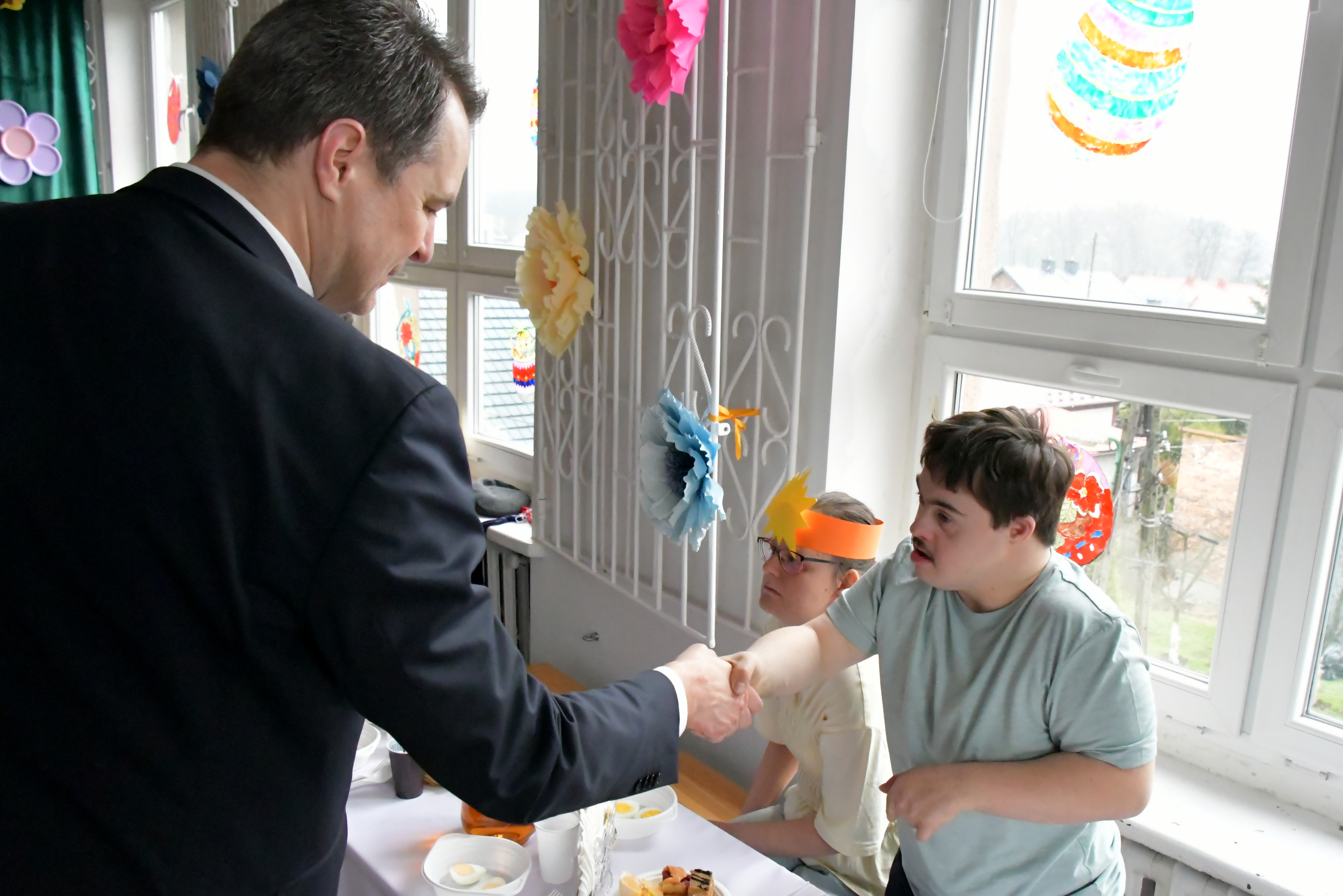 Starosta oświęcimski wita się z jednym z podopiecznych Stowarzyszenia Promyk w Oświęcimiu