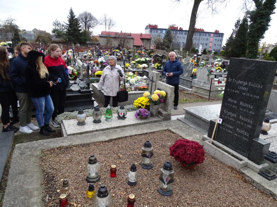 Nagrobek, a wokół niego stoją osoby.