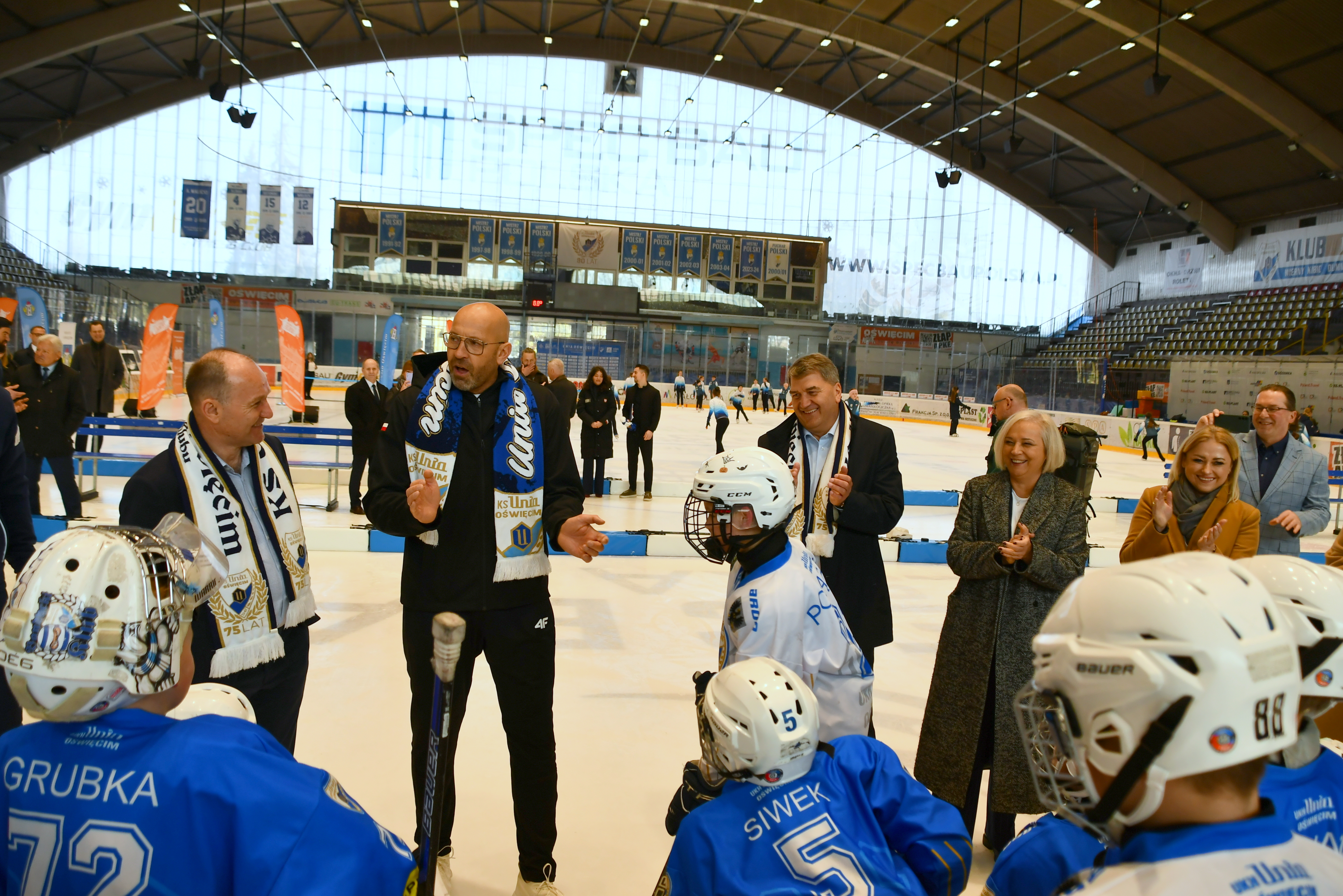 Na tafli oświęcimskiego lodowiska minister sportu rozmawia z młodymi adeptami hokeja