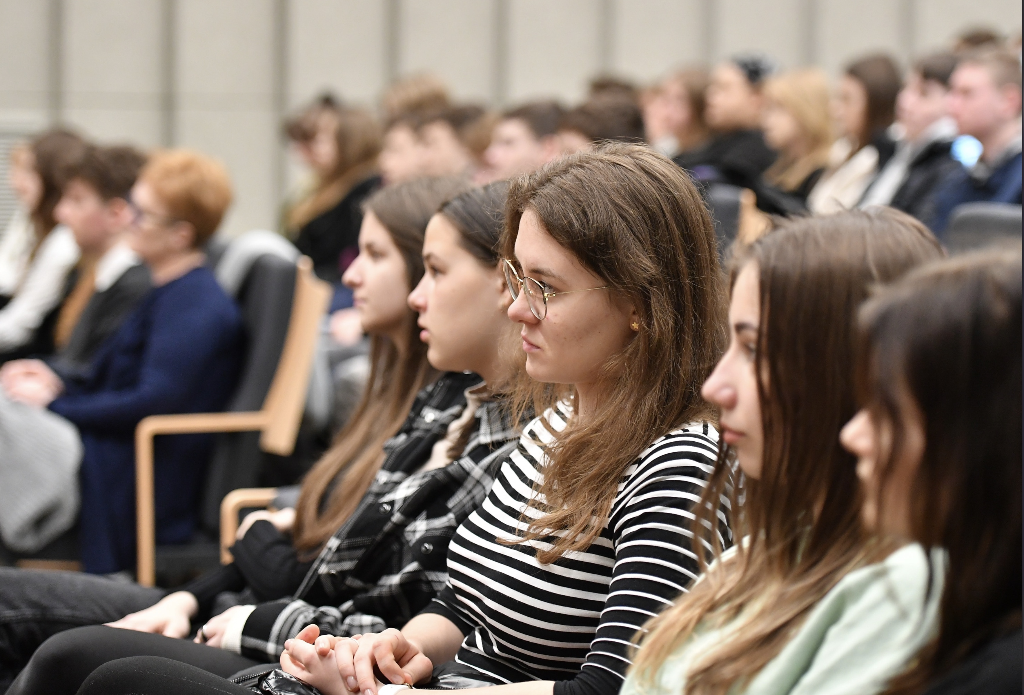 Na zdjęciu na pierwszym planie widoczna grupa młodych osób biorących udział w warsztatach i seminariach w Muzeum Auschwitz.