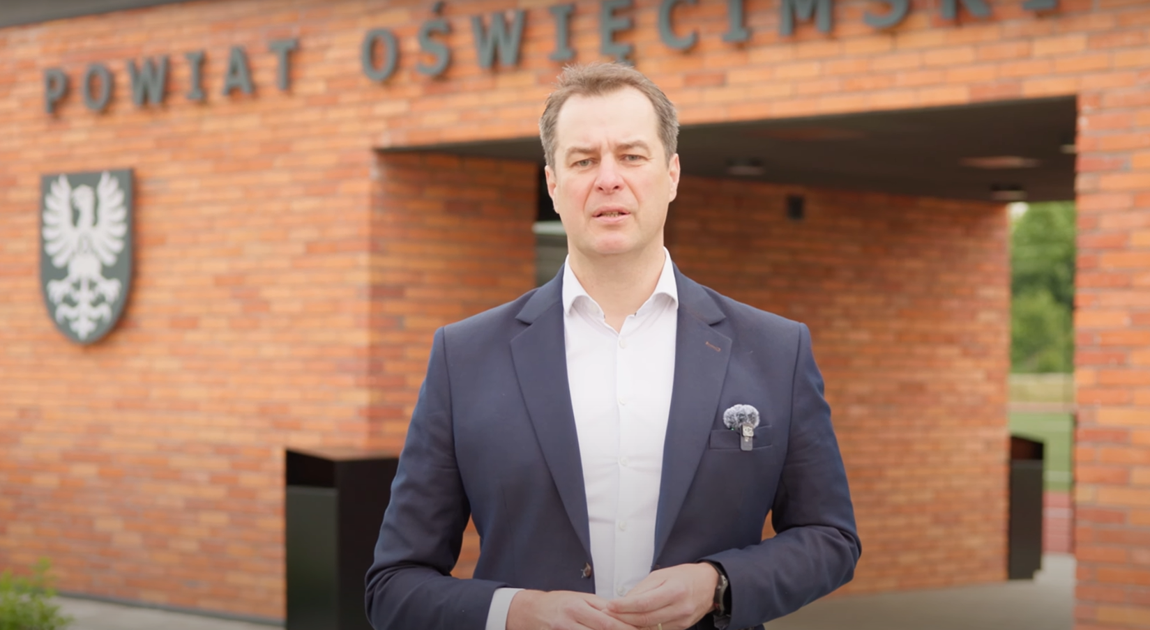 Starosta Oświęcimski przemawiający na tle budynku