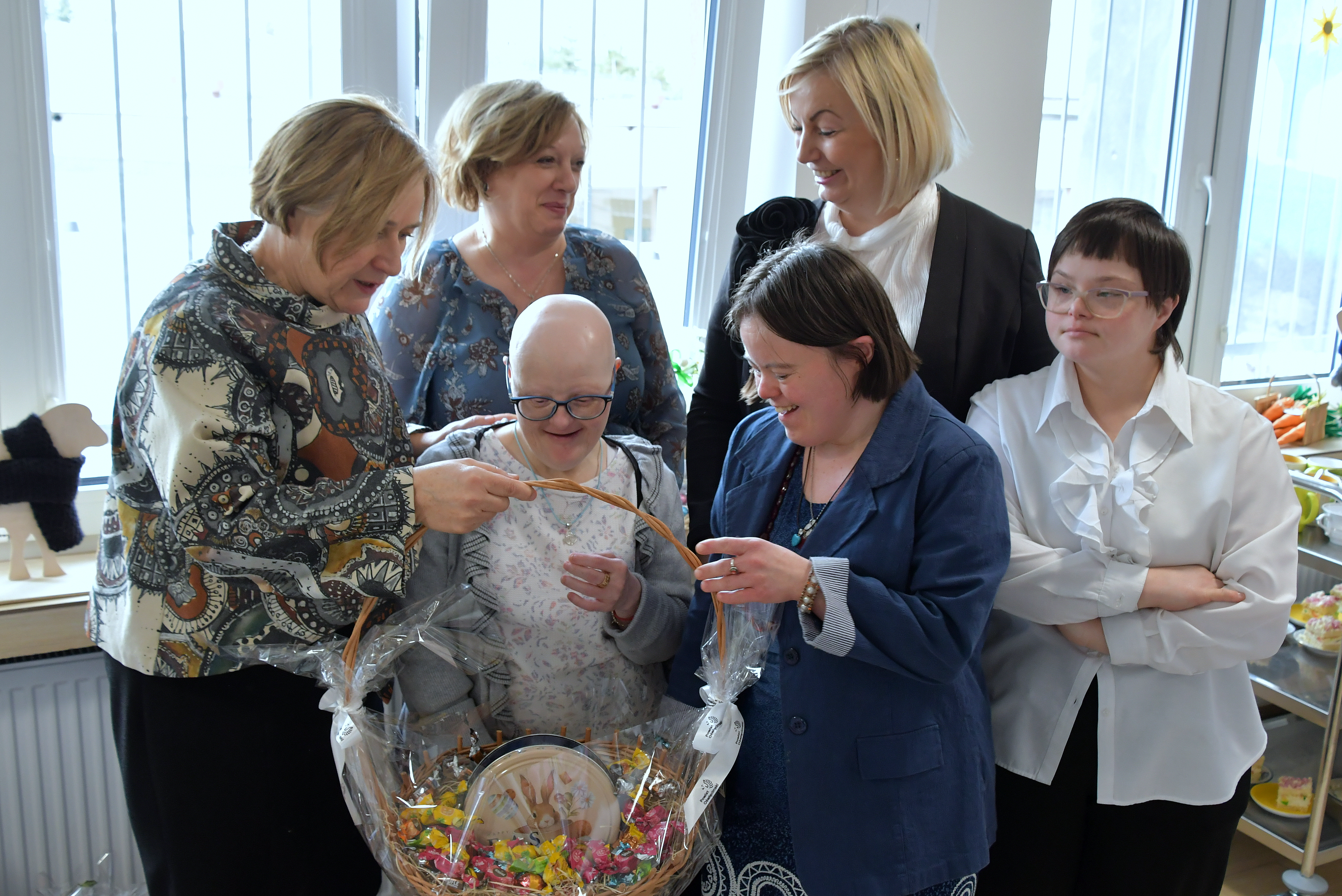 Włodarze Powiatu i dyrektorka placówki wraz z podopiecznymi i koszem słodyczy wręczanym przez wicestarostę