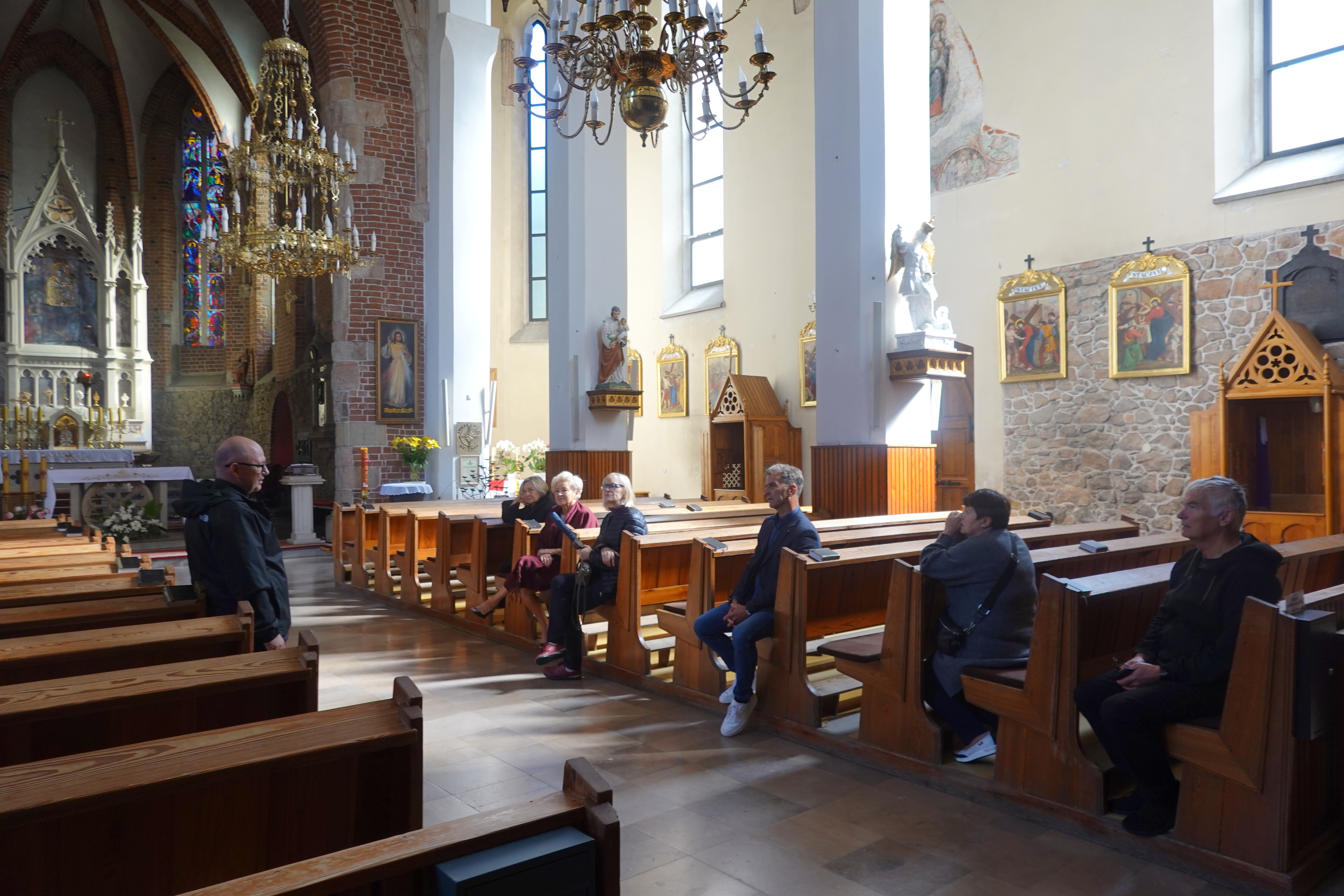 Grupa radnych wraz z przewodnikiem w kościele w Zatorze