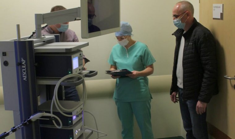 Po lewej stronie nowy sprzęt medyczny. Po prawej stronie pielęgniarka i osoba w czarnej kurtce.