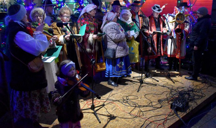 Grupa śpiewających na scenie kobiet i mężczyzn