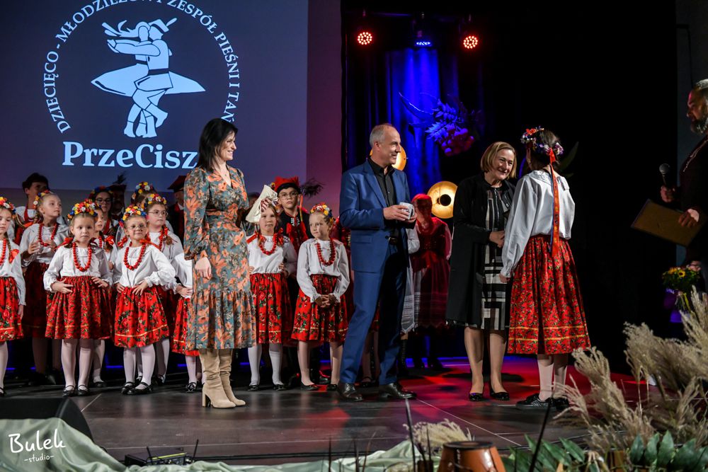 Członkini Zarządu Powiatu w Oświęcimiu wręcza laur i gratuluje przedstawicielce uhonorowanego zespołu