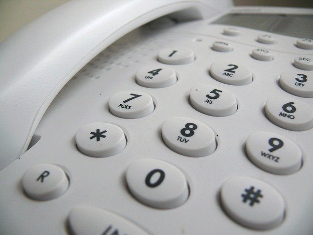 Na zdjęciu biała klawiatura telefonu stacjonarnego.