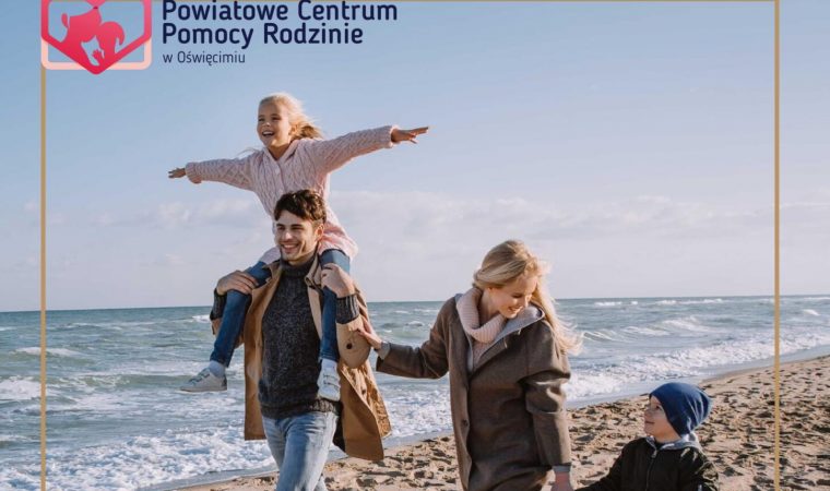 Mąż i żona idący z dwójką dzieci po plaży