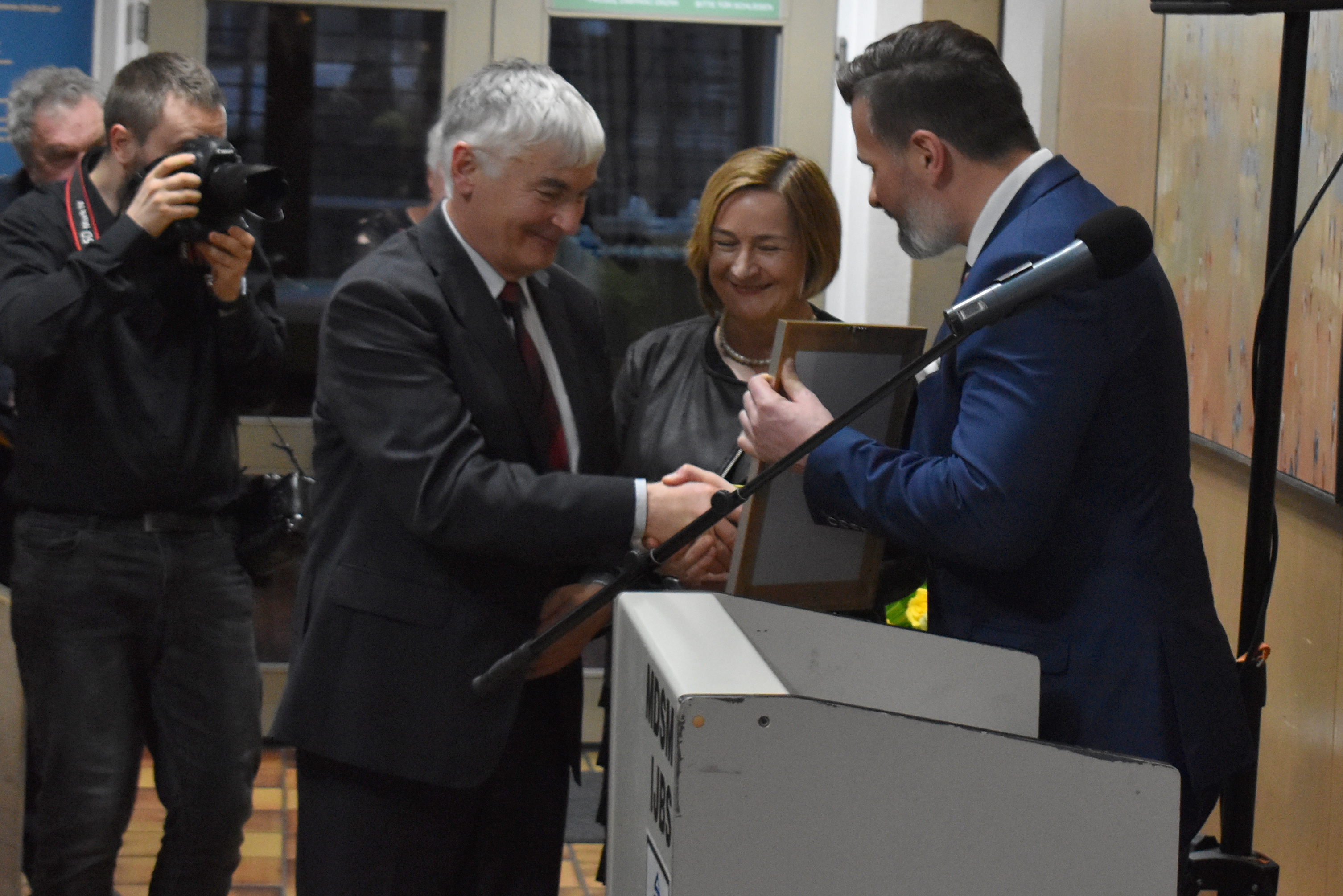 Odchodzący na emeryturę dyrektor Domu Spotkań w Oświęcimiu Leszek Szuster odbiera gratulacje i prezent z rąk włodarzy Powiatu Oświęcimskiego.