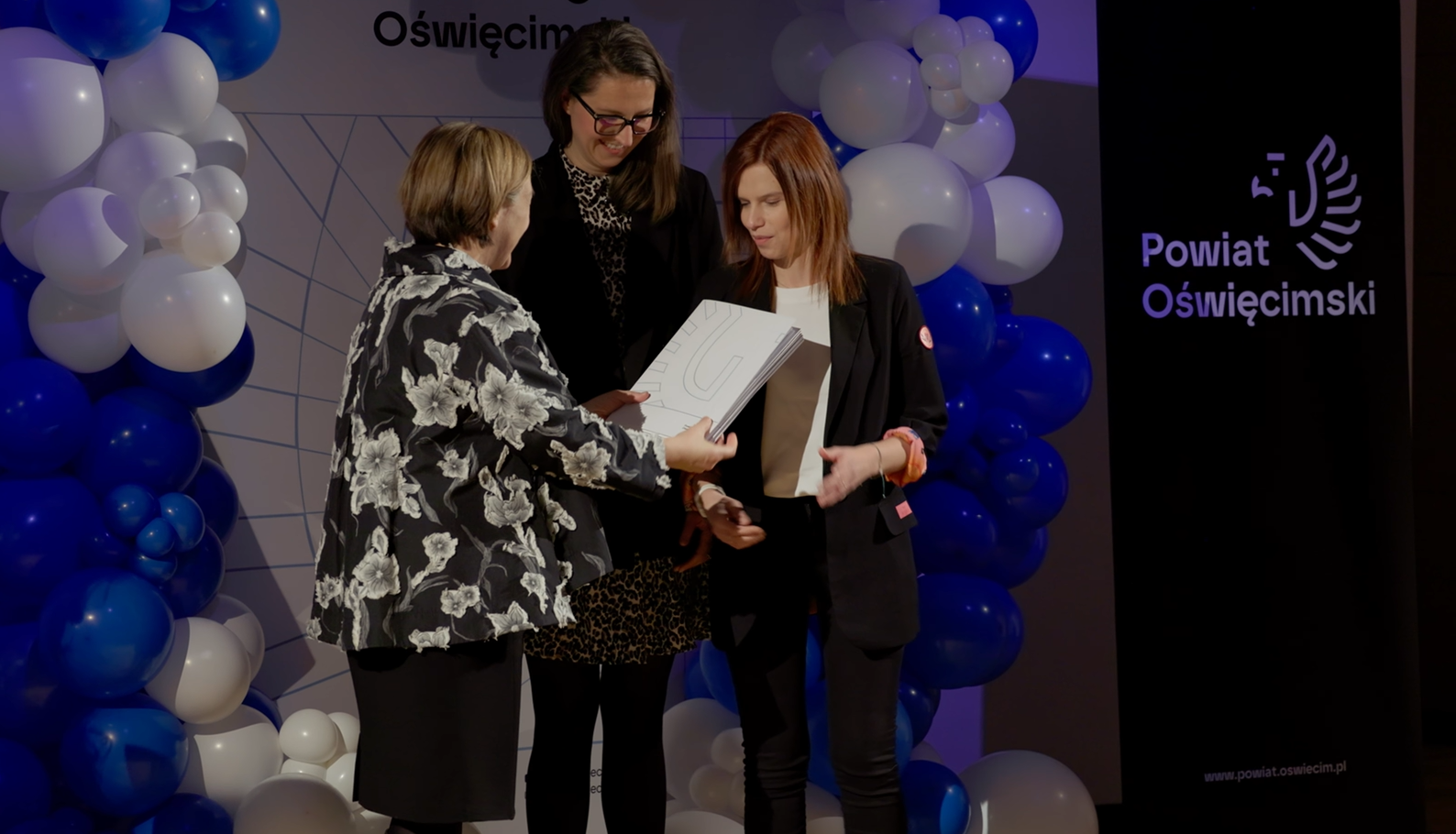 Na scenie wicestarosta wręcza umowę dwóch prezeskom fundacji Miasto Pracownia