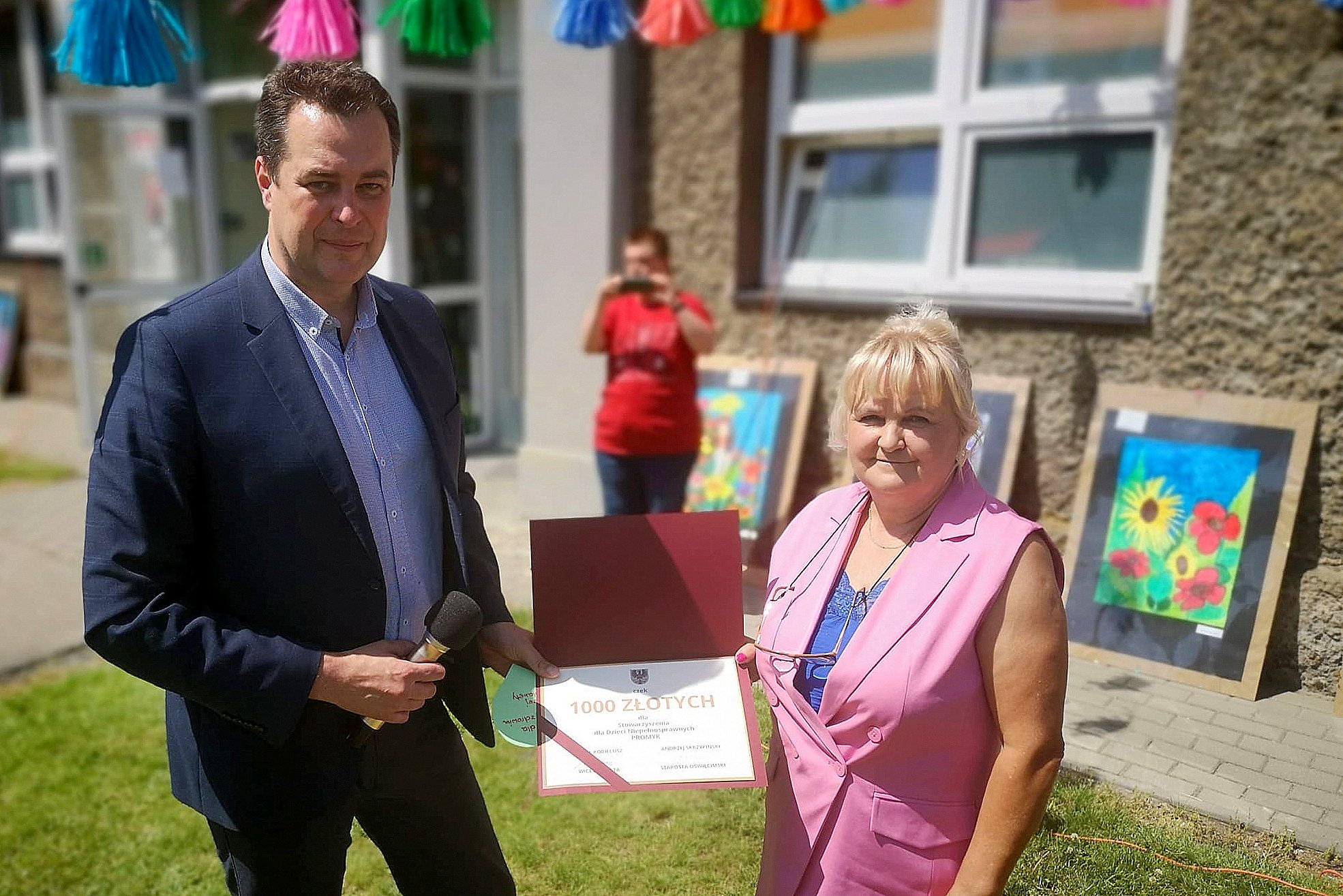 Na zdjęciu starosta oświęcimski przekazujący symboliczny czek na ręce pani prezes "Promyka".
