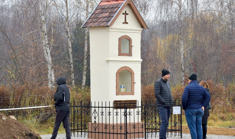 Odnowiona kapliczka wokół niej stoi kilka osób.