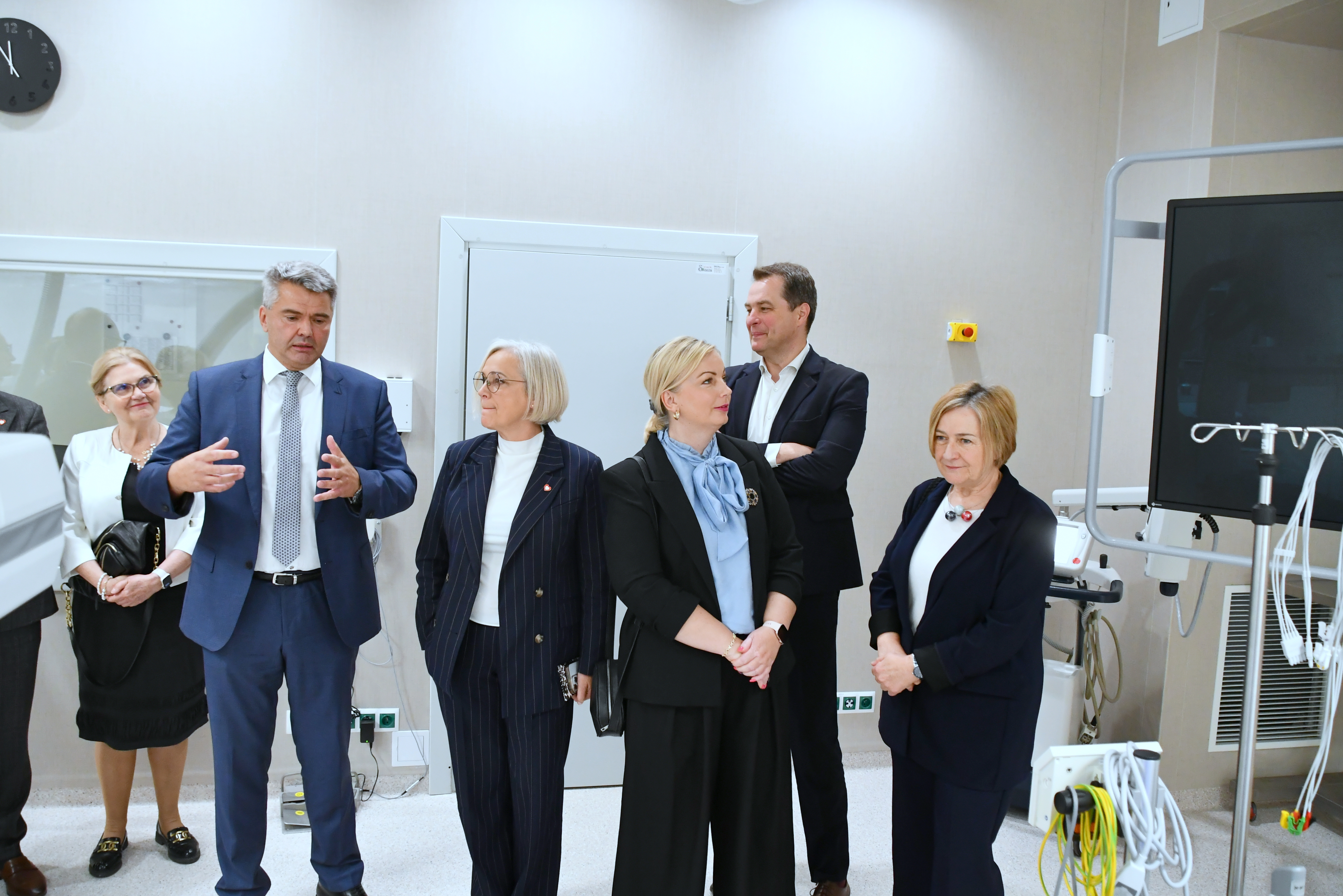 Zaproszeni goście słuchają słów prof. Dudka w nowoczesnej sali zabiegowej