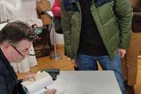 Autor podpisujący książkę o Księstwie Oświęcimskim.