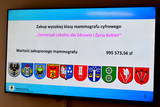 Informacja na ekranie o wartości sprzętu wraz z herbami gmin