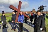 Niosący krzyż na terenie byłego obozu zagłady Birkenau uczestnicy Drogi Krzyżowej.