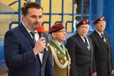 Mężczyzna w garniturze przemawia do czerwonego mikrofonu