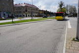 Zniszczona nawierzchnia drogi przed dworcem PKP w Oświęcimiu. W tle miejski autobus.
