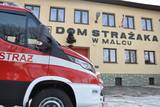 Wóz strażacki na tle domu strażaka w Malcu