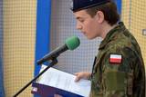 Osoba w mundurze czytająca informacje do mikrofonu